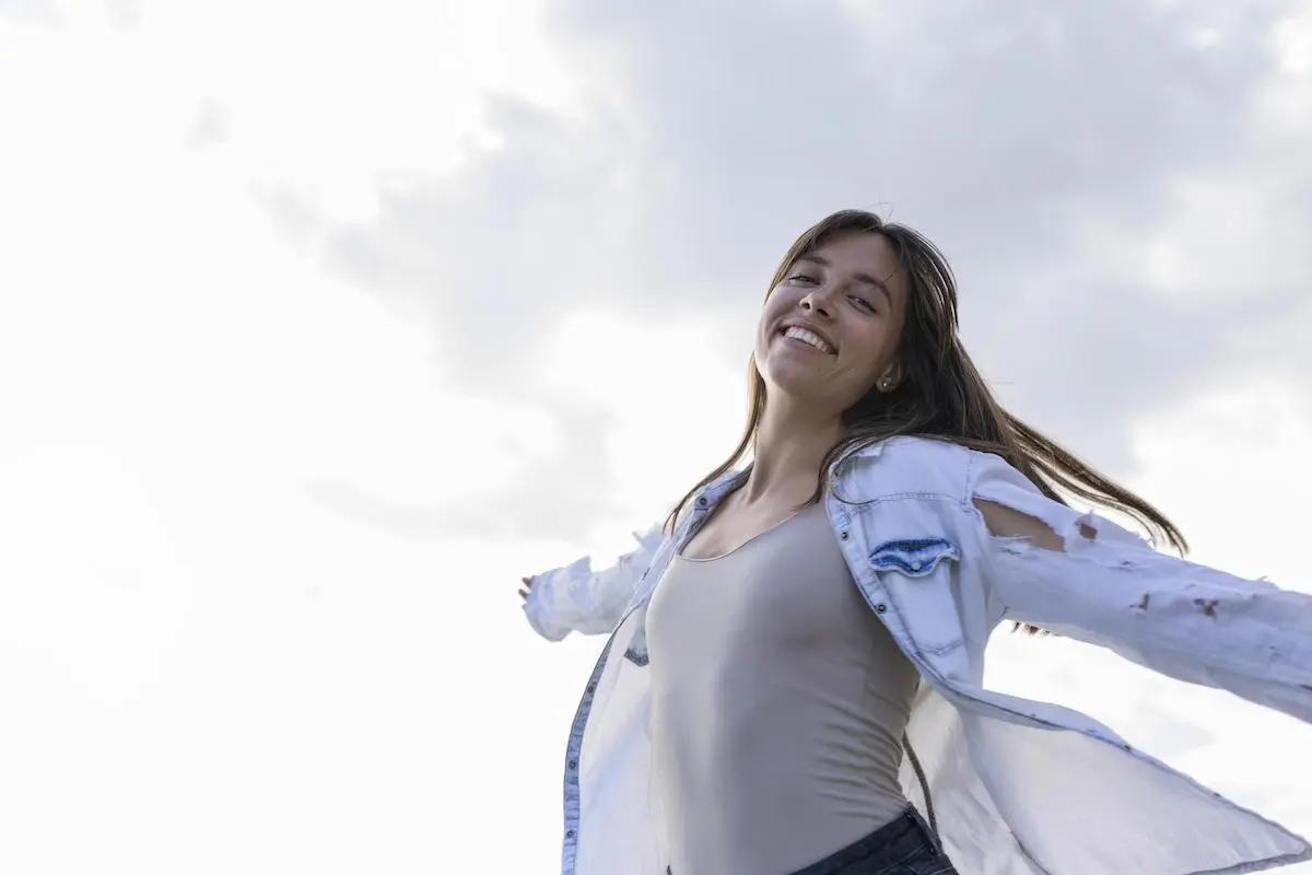 Mujer joven sonriendo al aire libre - Bienestar y felicidad en Centro Médico Phillips